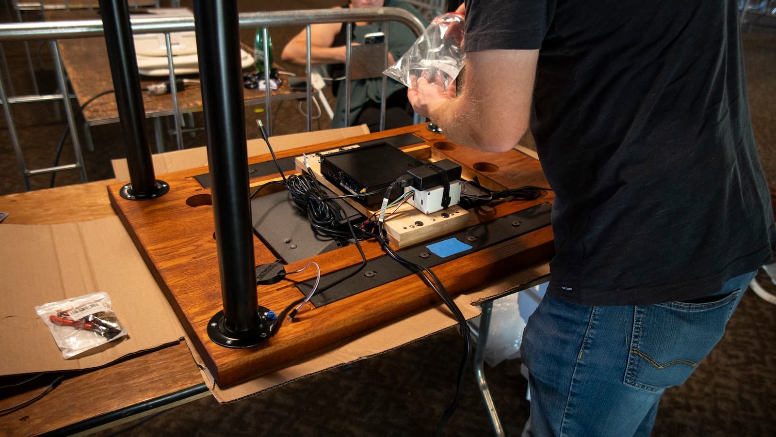 Bolting the legs and reader electronics onto the underside of the custom wooden tabletop