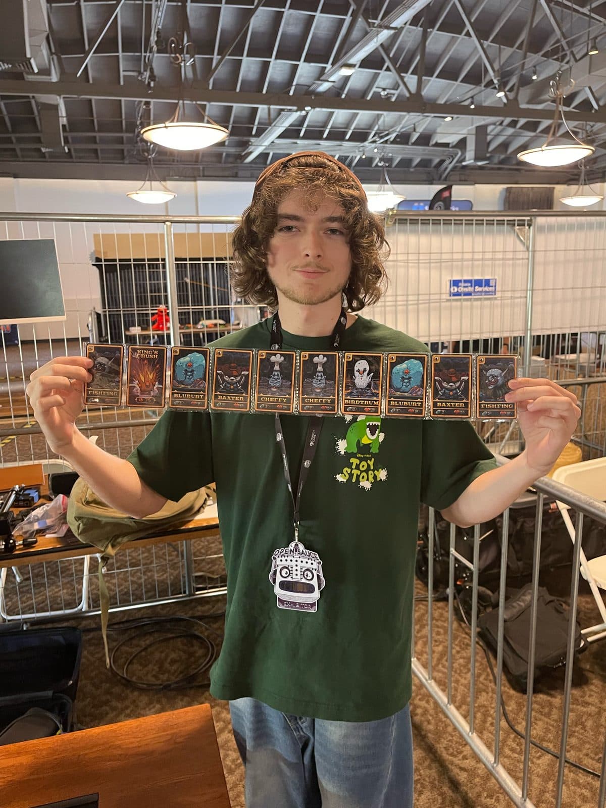 A team member holding up a connected strip of printed UVULITES cards at an event booth
